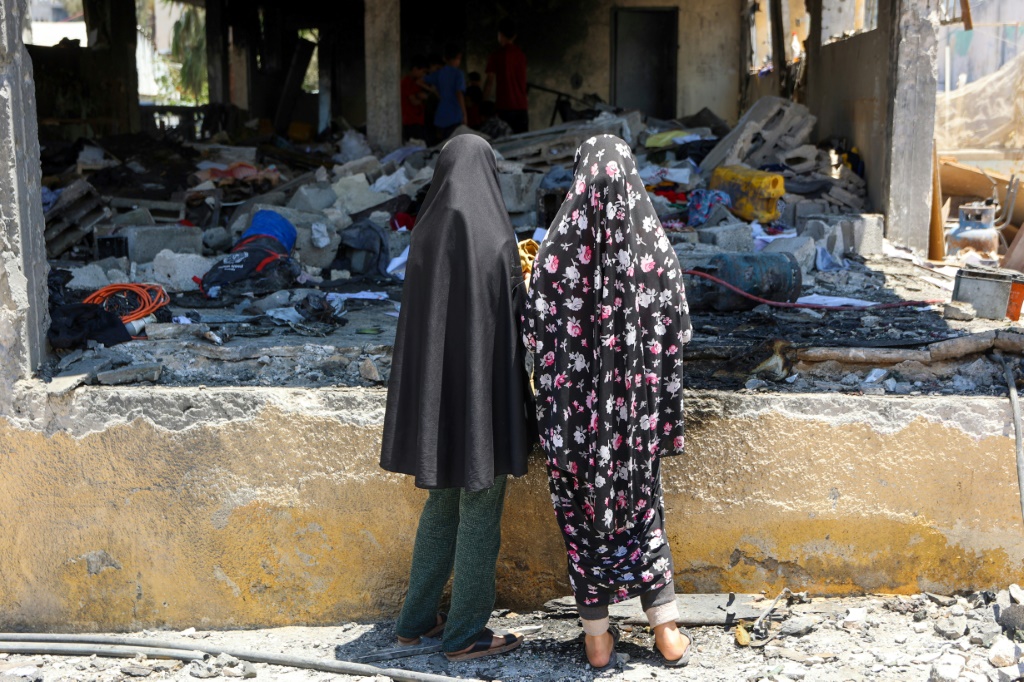 فلسطينيتان تتفقدان الدمار في مدرسة مصطفى حافظ في مدينة غزة بعد ضربة إسرائيلية في 3 تموز/يوليو 2025 (أ ف ب)