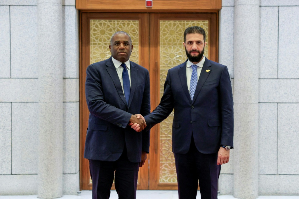 الرئيس السوري الانتقالي احمد الشرع مصافحا وزير الخارجية البريطاني ديفيد لامي في دمشق في الخامس من تموز/يوليو 2025 (أ ف ب)