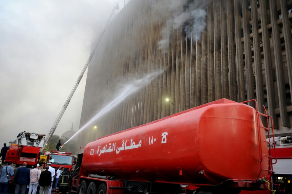 رجال الإطفاء يخمدون النيران بعد اندلاع حريق في محطة سنترال رمسيس للاتصالات في وسط القاهرة في 7 تموز/يوليو 2025 (أ ف ب)