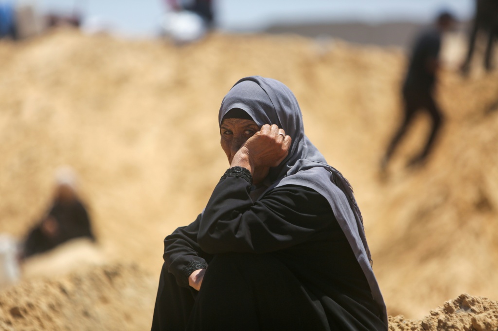 امرأة فلسطينية تجلس بين الخيام المدمرة بعد اقتحام الدبابات الإسرائيلية لمنطقة خان يونس جنوب قطاع غزة في 11 تموز/يوليو 2025 (أ ف ب)