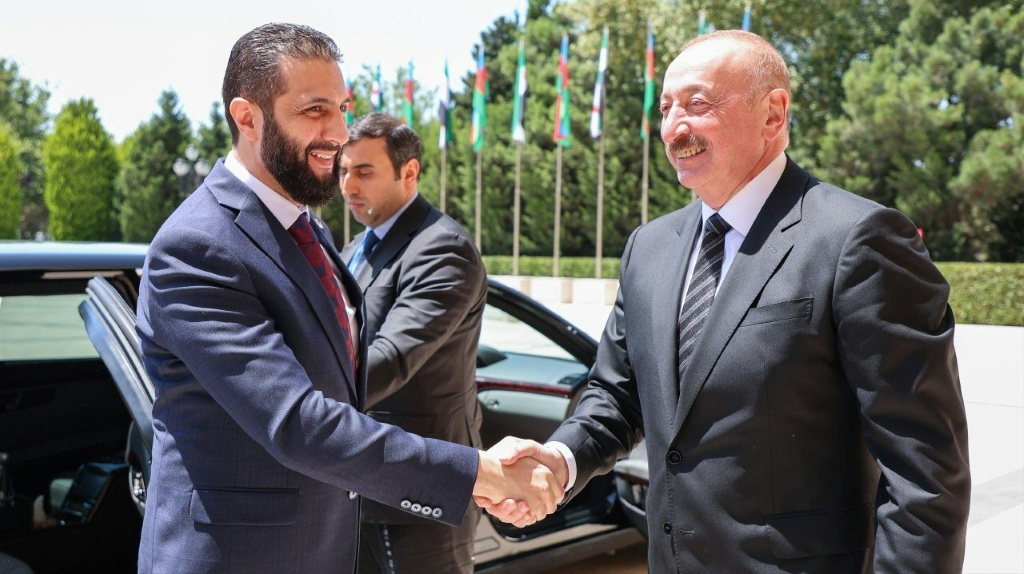 الرئيس الأذربيجاني إلهام علييف (يمين) مستقبلا الرئيس السوري الانتقالي أحمد الشرع في باكو في 12 تموز/يوليو 2025 (أ ف ب)
