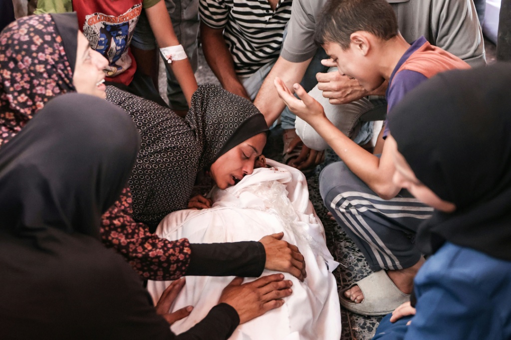 فلسطينيون ينتحبون على قريب قتل في ضربة إسرائيلية، في المستشفى المعمداني في مدينة غزة في 13 تموز/يوليو 2025 (أ ف ب)