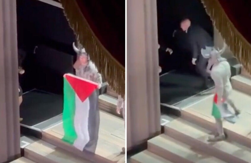 فشلوا في انتزاعه منه.. فنان يرفع علم فلسطين على مسرح دار الأوبرا الملكية في بريطانيا (لقطة من فيديو متداول على منصة إكس)
