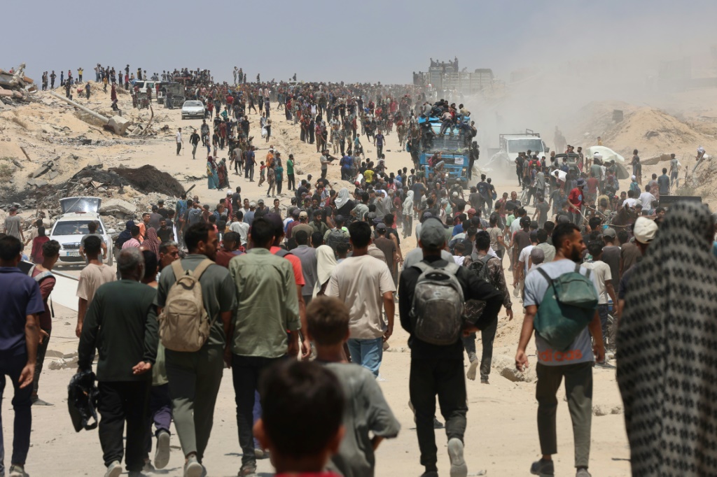 صورة مؤرخة في 22 تموز/يوليو 2025 لفلسطينيين في جباليا في شمال قطاع غزة يتجهون نحو شاحنات محملة بالمساعدات الانسانية (أ ف ب)