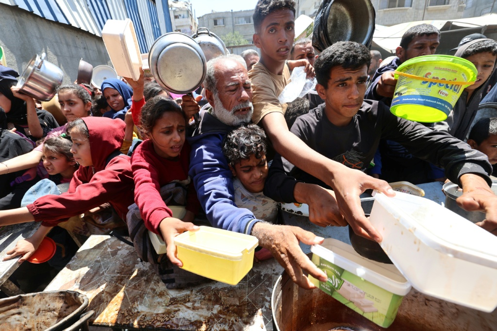 طوابير لأطفال فلسطين لسعي للحصول على وجبة طعام في قطاع غزة (أ ف ب)
