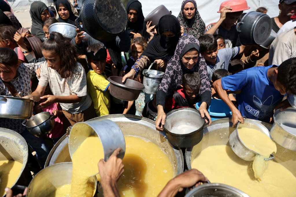 فلسطينيون ينتظرون الحصول على طعام في نقطة لتوزيع الغذاء في مدينة غزة في الأول من آب/أغسطس 2025 (أ ف ب)