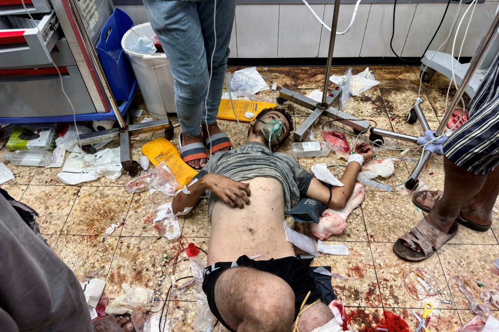 جريح فلسطيني ممدد على الأرض في قسم الطوارئ بمستشفى ناصر في خان يونس بعد إصابته أثناء انتظاره للحصول على طعام بالقرب من مركز توزيع بين مدينتي خان يونس ورفح جنوب قطاع غزة، في 24 تموز/يوليو 2025 (ا ف ب)