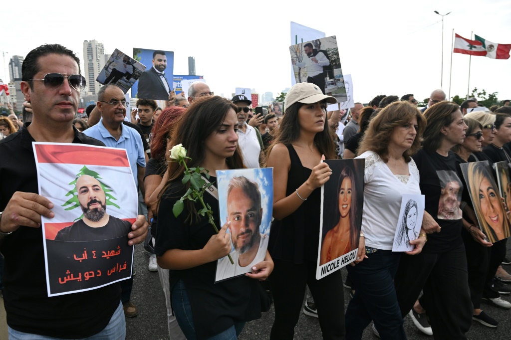 لبنانيون يحملون في 4 آب/أغسطس 2025 صور أحبائهم ممن قضوا في انفجار مرفأ بيروت المروّع، أثناء إحياء الذكرى السنوية الخامسة للفاجعة، على وقع مطالبة عائلات الضحايا بتحقيق عدالة طال انتظارها (أ ف ب)