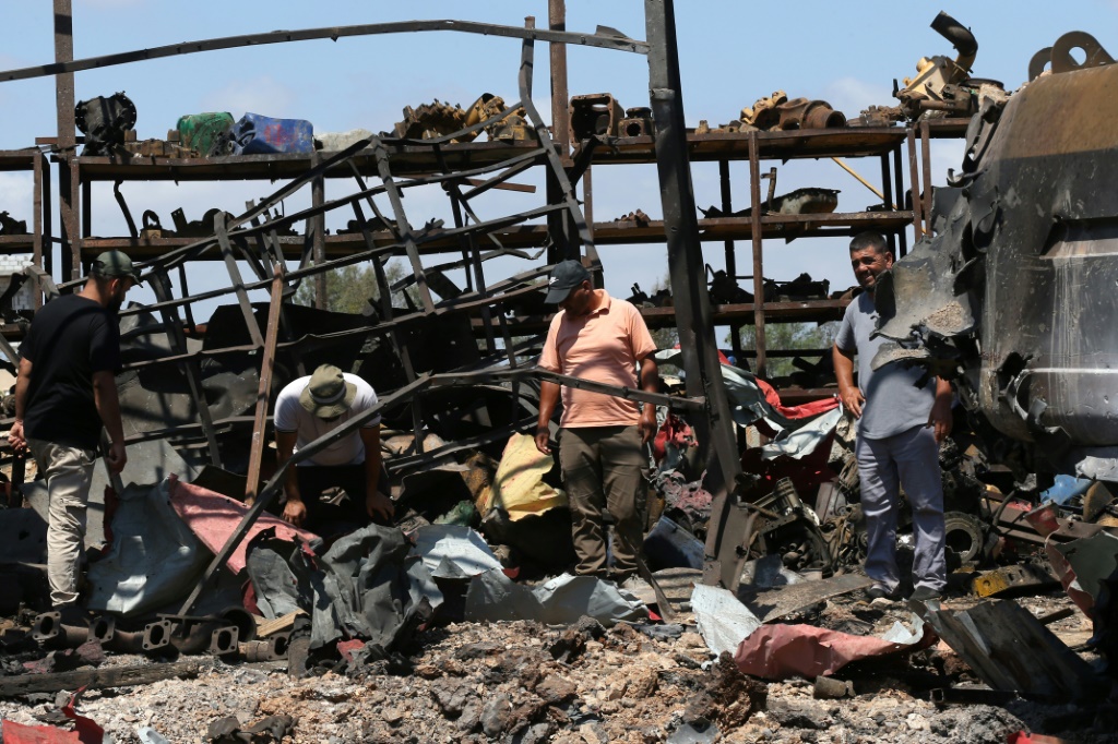 أشخاص يعاينون آثار ضربات إسرائيلية على بلدة دير سريان في جنوب لبنان في السابع من آب/أغسطس 2025 (أ ف ب)