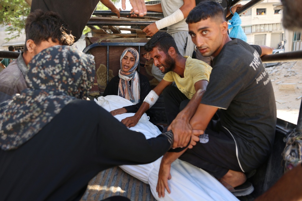فلسطينيون يبكون قريبا قضى أثناء انتظاره للحصول على الطعام عند معبر زيكيم، قبل تشييعه، في مستشفى الشفاء في مدينة غزة في 5 آب/أغسطس 2025 (أ ف ب)
