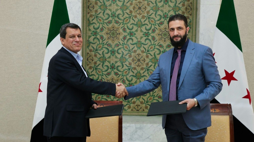 صورة وزعتها وكالة الأنباء السورية الرسمية "سانا" في 10 آذار/مارس 2025، ويبدو فيها الرئيس الانتقالي أحمد الشرع مصافحا قائد قوات سوريا الديمقراطية مظلوم عبدي، بعيد توقيع اتفاق لدمج مؤسسات الإدارة الذاتية الكردية في إطار الدولة السورية (أ ف ب)