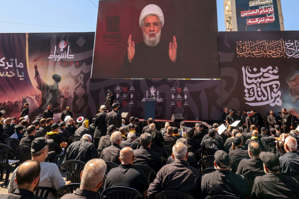 الأمين العام لحزب الله نعيم قاسم يتحدث عبر الشاشة أمام مناصري الحزب في السادس من تموز/يوليو 2025 (أ ف ب)