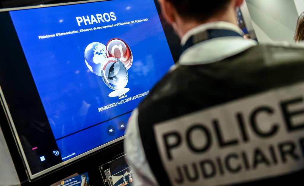 شرطي أمام جهاز يُظهر منصة PHAROS (منصة التنسيق والتحليل والاسترداد وتوجيه الإشارات)، التي تسمح بالإبلاغ عن المحتوى والسلوك غير القانوني على الإنترنت، خلال المنتدى الدولي العاشر للأمن السيبراني في مدينة ليل الفرنسية في 23 كانون الثاني/يناير 2018 (أ ف ب)