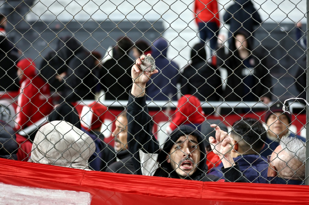 أحد مشجعي فريق إنديبندينتي الأرجنتيني يحمل حجرا أثناء توقف مباراة إياب دور الـ16 من بطولة كوبا سود أميركانا لكرة القدم بين إنديبندينتي ويونيفرسيداد دي تشيلي التشيلي على ملعب ليبرتادوريس دي أمريكا. بوينس آيرس، الأرجنتين، في 20 آب/أغسطس 2025(أ ف ب)
