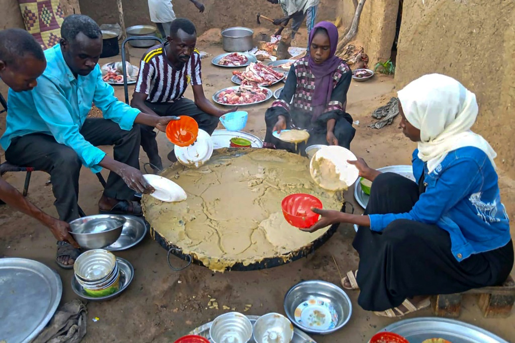 سودانيون يتلقون وجبات مجانية في الفاشر وهي مدينة تحاصرها قوات الدعم السريع منذ أكثر من عام، في منطقة دارفور، في 11 آب/أغسطس 2025 (أ ف ب)