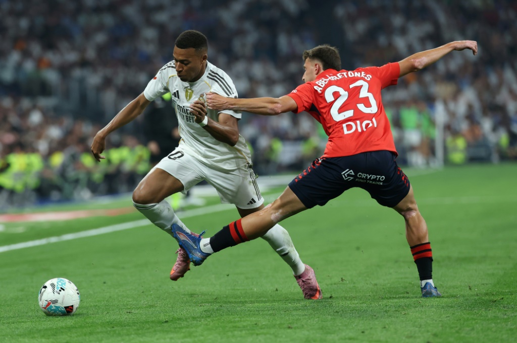 صراع على الكرة بين المهاجم الفرنسي لريال مدريد كيليان مبابي (#10) والمدافع الإسباني لأوساسونا أبيل بريتونيس (#24) خلال مواجهة الفريقين ضمن الدوري الإسباني لكرة القدم على ملعب سانتياغو برنابيو. مدريد في 19 آب/أغسطس 2025. (أ ف ب)