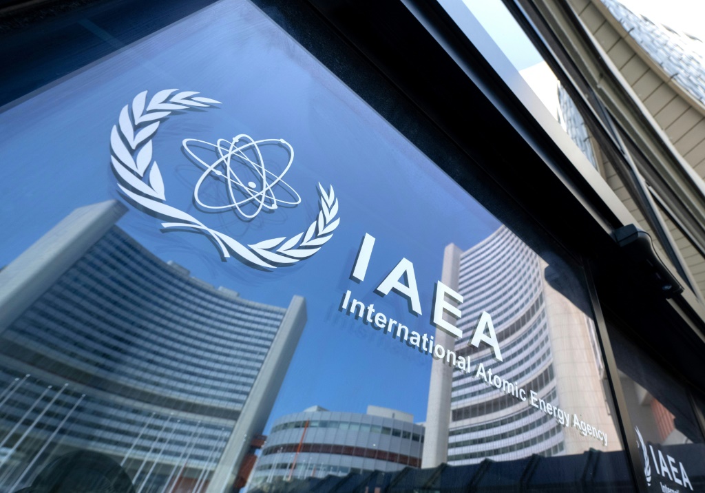 انعكاس مباني مقر الوكالة الدولية للطاقة الذرية على أبواب عليها شعار الوكالة في فيينا، في 13 حزيران/يونيو 2025 (أ ف ب)