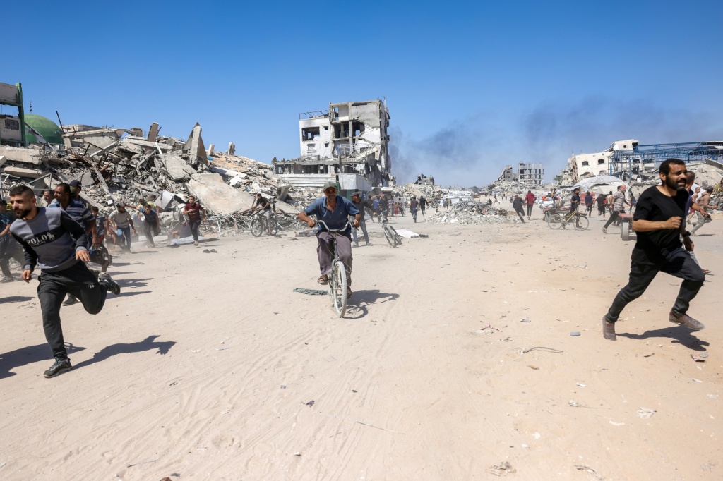 فلسطينيون يركضون بحثا عن ملجأ إثر غارة لطائرة إسرائيلية مسيّرة في شمال غزة في 23 أيار/مايو 2025 (أ ف ب)