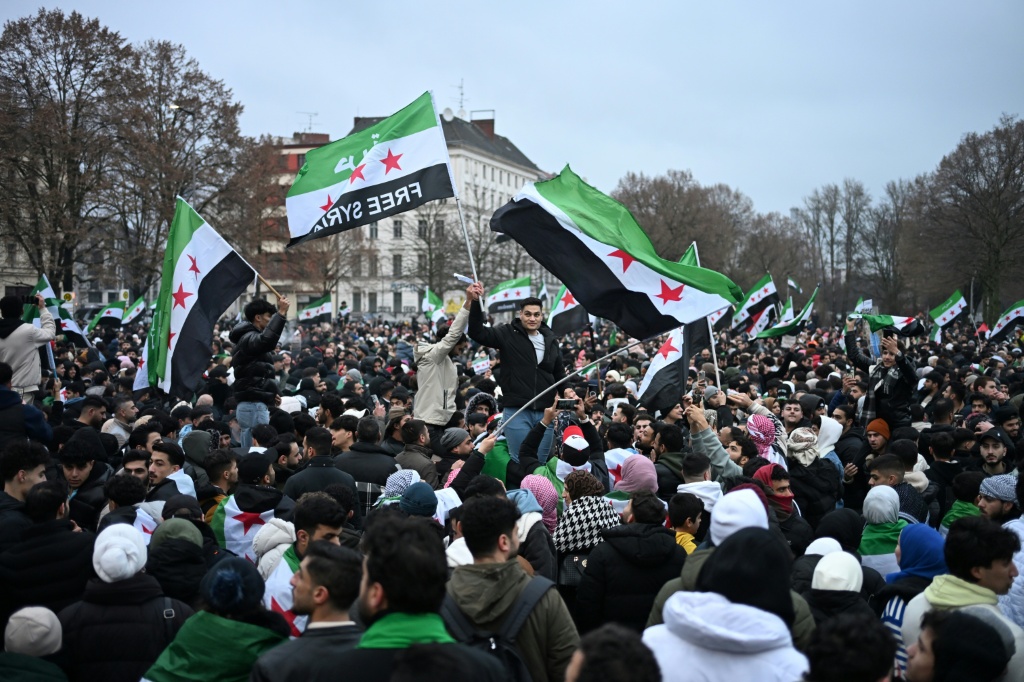 سوريون في برلين أثناء احتفالهم بسقوط نظام بشار الأسد في الثامن من كانون الأول/ديسمبر 2024 (أ ف ب)
