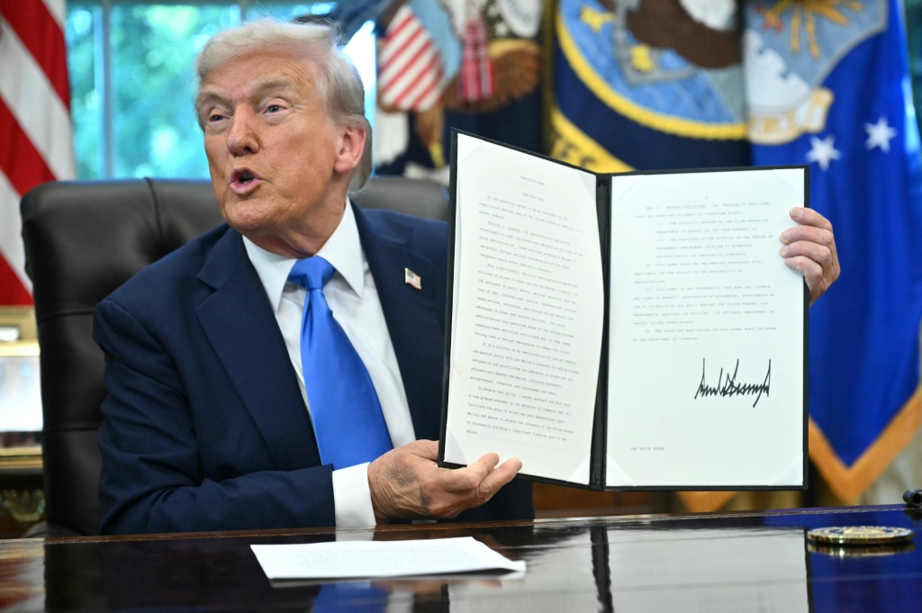 الرئيس الأميركي دونالد ترامب يعرض قرارا تنفيذيا إثر توقيعه في المكتب البيضوي في البيت الأبيض في 19 أيلول/سبتمبر 2025 (ا ف ب)