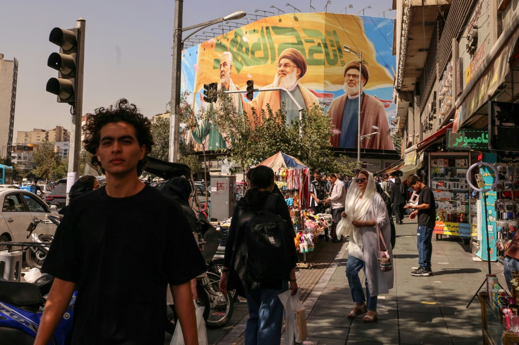 لافتة في أحد شوارع طهران عليها صورة الامين العام لحزب الله اللبناني حسن نصرالله (وسط) والقيادي البارز في الحزب هاشم صفي الدين (يسار) اللذين اغتالتهما إسرائيل والجنرال قاسم سليماني، في 28 أيلول/سبتمبر 2025 (أ ف ب)