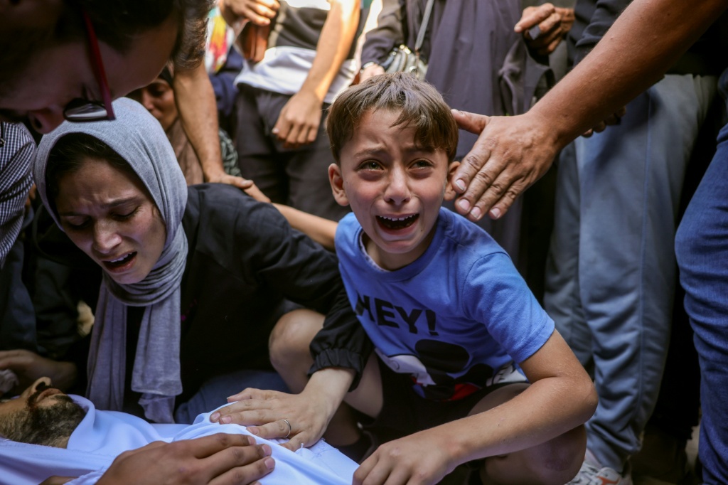 عائلة تبكي أحد أفرادها الذي قتل في قصف إسرائيلي في دير البلح في وسط قطاع غزة في الأول من تشرين الأول/أكتوبر 2025 (أ ف ب)