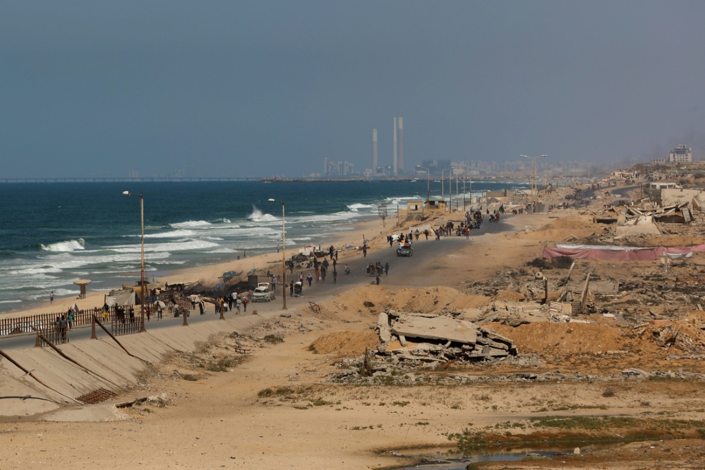 فلسطينيون يسيرون على طريق ساحلي شمال غرب مخيم النصيرات للاجئين أثناء نزوحهم جنوبا من وادي غزة بعد إعلان إسرائيل إغلاق طريق الرشيد باتجاه شمال القطاع المحاصر في 2 تشرين الأول/أكتوبر 2025 (أ ف ب)