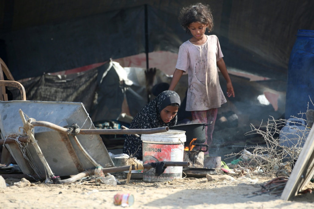 طفلتان فلسطينيتان نازحتان في مخيم النصيرات بوسط قطاع غزة المحاصر والمدمر في الرابع من تشرين الأول/أكتوبر 2025 (أ ف ب)