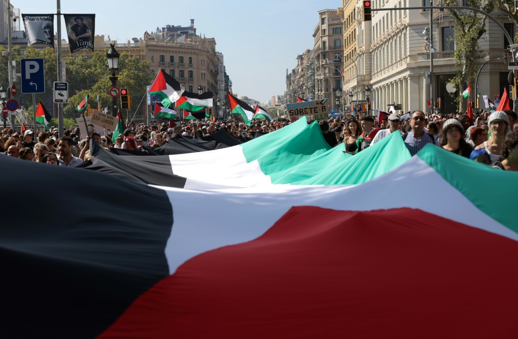متظاهرون في مدينة برشلونة يرفعون علما فلسطينيا عملاقا في الرابع من تشرين الأول/أكتوبر 2025 (أ ف ب)