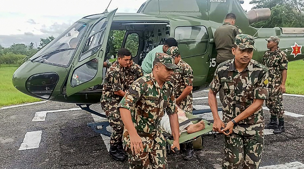 صورة نشرها جيش النيبال في 5 تشرين الأول/أكتوبر 2025 تظهر أفرادا من الجيش يحملون ضحية انهيار أرضي تم إجلاؤه بواسطة مروحية في أعقاب الانهيارات الأرضية والفيضانات الناجمة عن الأمطار الغزيرة (ا ف ب)