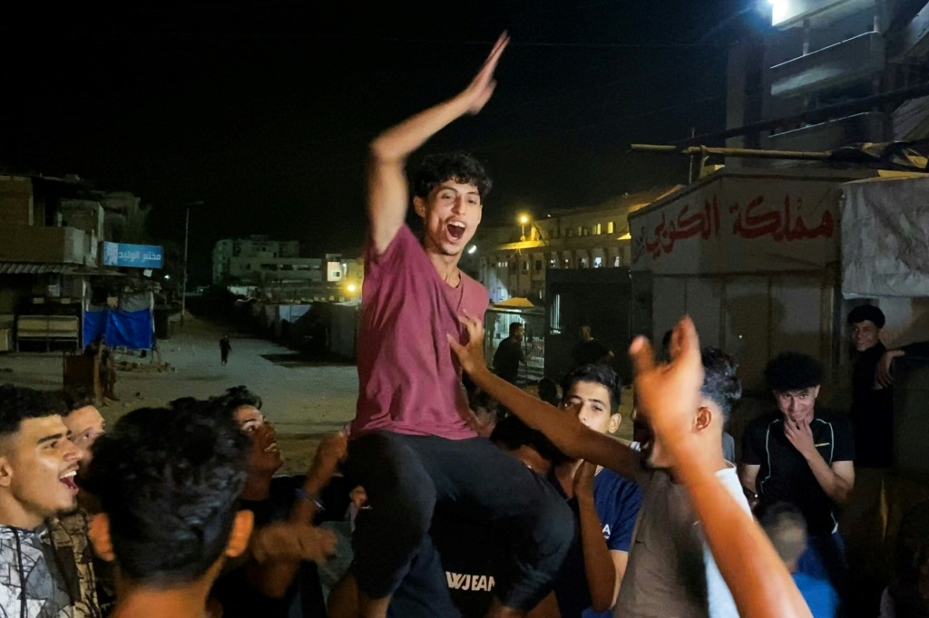 فلسطينيون يحتفلون في خان يونس في التاسع من تشرين الاول/اكتوبر 2025 بعد أنباء عن التوصل إلى اتفاق لوقف إطلاق النار في قطاع غزة بعد عامين من الحرب المدمرة (أ ف ب)