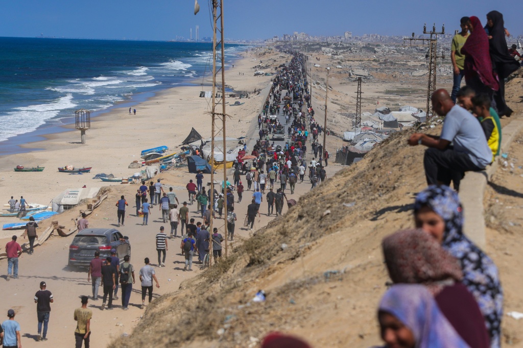 فلسطينيون على طريق الرشيد في منطقة النصيرات في وسط قطاع غزة بعد إعلان وقف لإطلاق النار في العاشر من تشرين الأول/أكتوبر 2025 (ا ف ب)