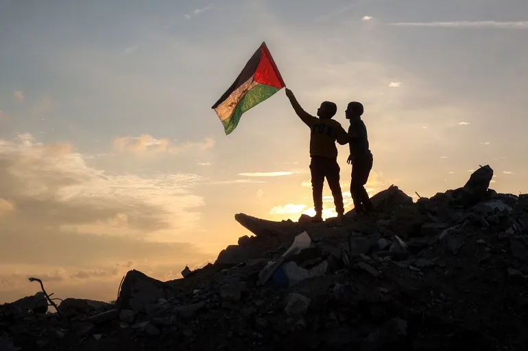 اطفال غزة يرفعون العلم الفلسطيني (أ ف ب)
