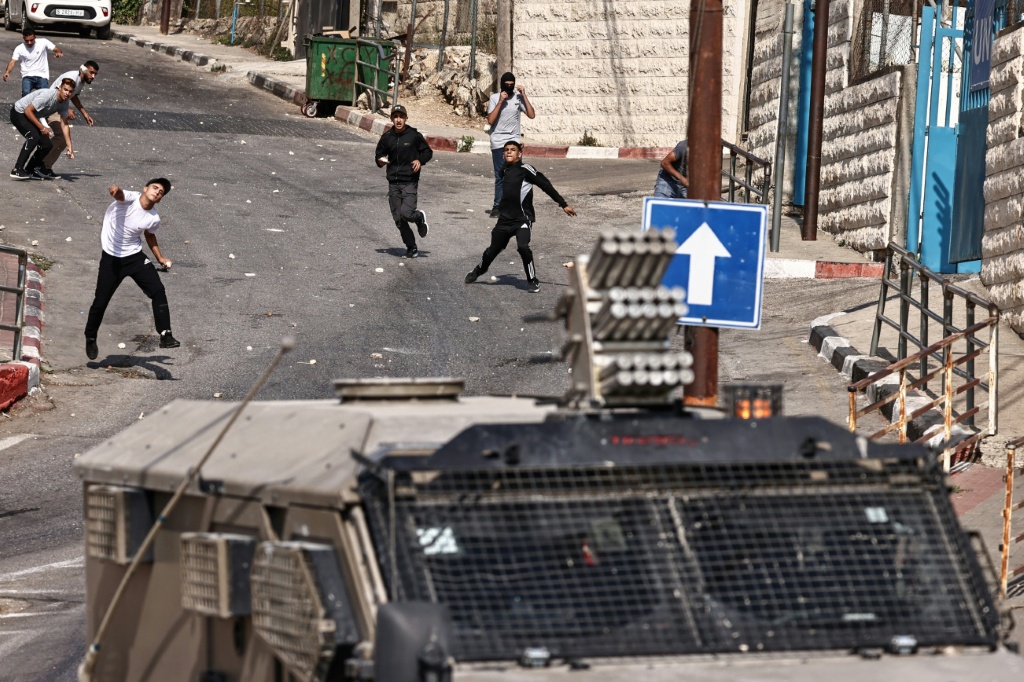 فلسطينيون يلقون الحجارة على جنود الاحتلال الإسرائيليين في رام الله بتاريخ 16 ايلول/سبتمبر 2025 (ا ف ب)