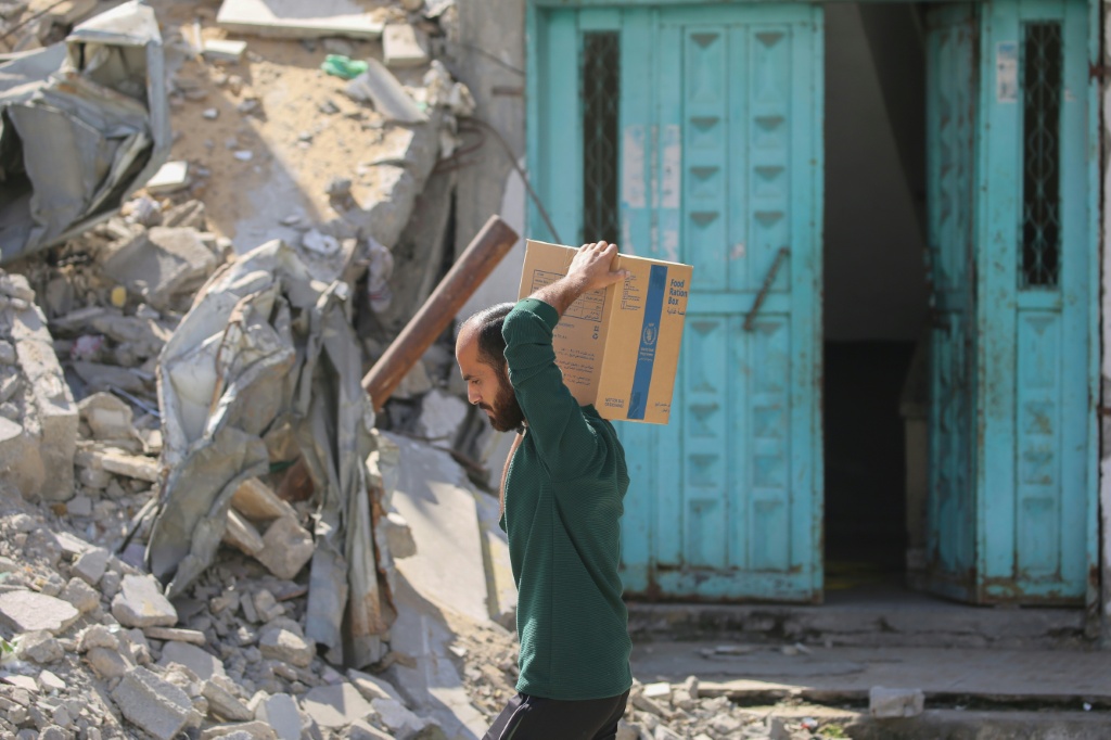 نازح فلسطيني يحمل صندوق إسعافات أولية حصل عليه من مركز مساعدات في مخيم النصيرات في وسط قطاع غزة في 19 تشرين الأول/أكتوبر 2025 (ا ف ب)