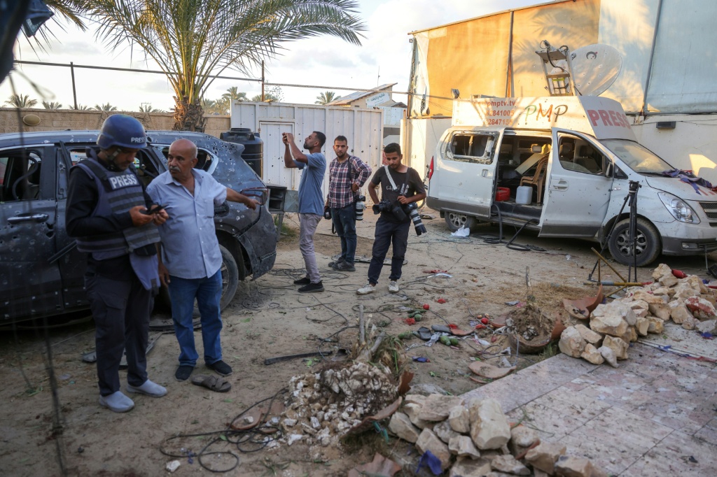 مدنيون وصحافيون يتفقدون الأضرار بعد ضربة إسرائيلية ذكرت تقارير بأنها استهدفت منزلا قرب دير البلح وسط غزة بتاريخ 19 تشرين الاول/أكتوبر 2025 (ا ف ب)