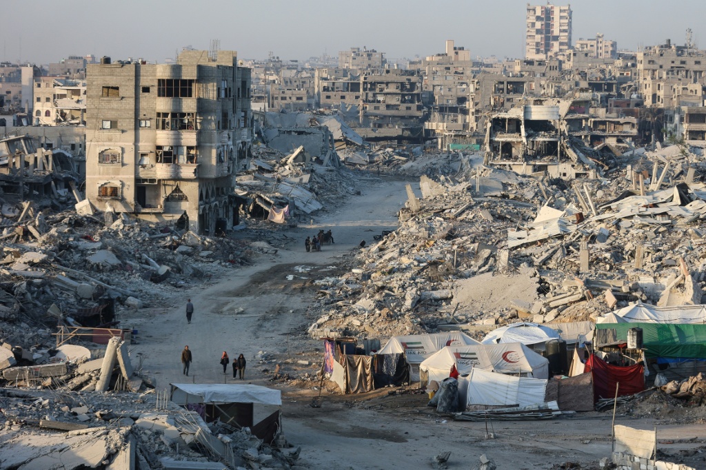 نازحون فلسطينيون يتلقون مساعدات غذائية خارج مسجد الامام الشافعي المدمر في حي الزيتون بمدينة غزة في 23 تشرين الاول/اكتوبر 2025 (ا ف ب)