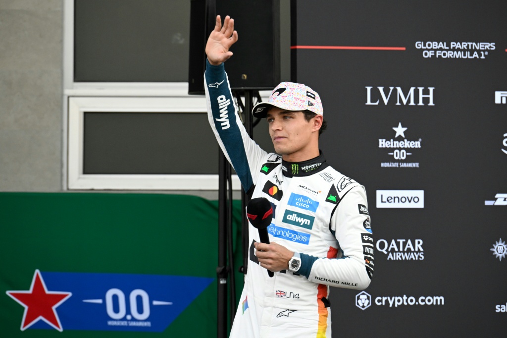 سائق ماكلارين البريطاني لاندو نوريس يحيي الجماهير عقب انتزاعه المركز الاول في التجارب الرسمية لسباق جائزة المكسيك الكبرى في مكسيكو في 25 تشرين الأول/أكتوبر 2025 (ا ف ب)