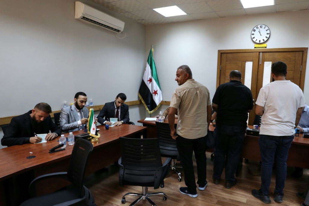 مواطنون سوريون يسجلون في مكتب خدمات تابع للسفارة السورية في طرابلس في 25 تشرين الأول/أكتوبر 2025 بعد أن أعلنت وزارة الخارجية السورية أنها ستمنح تذاكر عودة مجانية لمواطنيها الراغبين في مغادرة ليبيا (ا ف ب)