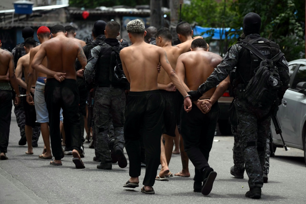 عناصر من الشرطة يقتادون مشتبهين أُوقفوا خلال عملية أمنية ضد تجار مخدرات بمدينة ريو دي جانيرو في البرازيل، في 28 تشرين الأول/أكتوبر 2025 (ا ف ب)