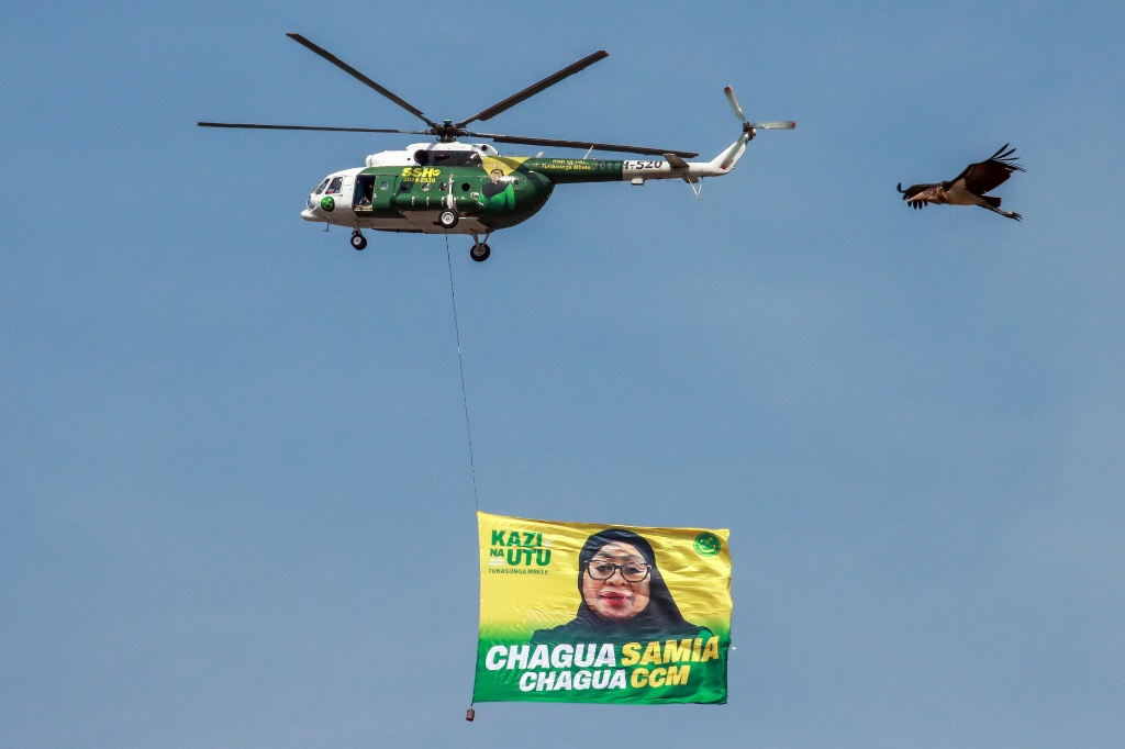 مروحية تحمل لافتة عليه صورة الرئيسة سامية صولوحو حسن في ختام الحملة الانتخابية لحزبها في موانزا في 28 تشرين الأول/أكتوبر 2025 (ا ف ب)