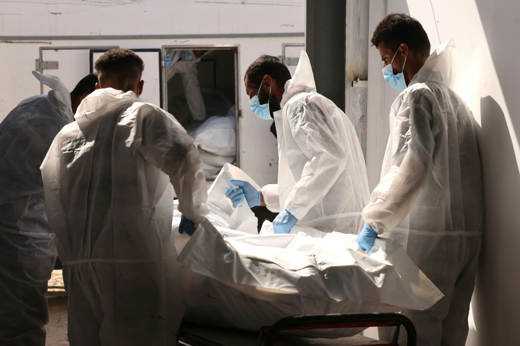 موظفو مستشفى ناصر في خان يونس جنوب قطاع غزة ينقلون إحدى الجثث التي سلمتها السلطات الإسرائيلية إلى غزة عبر الصليب الأحمر في 31 تشرين الأول/أكتوبر 2025 (ا ف ب)