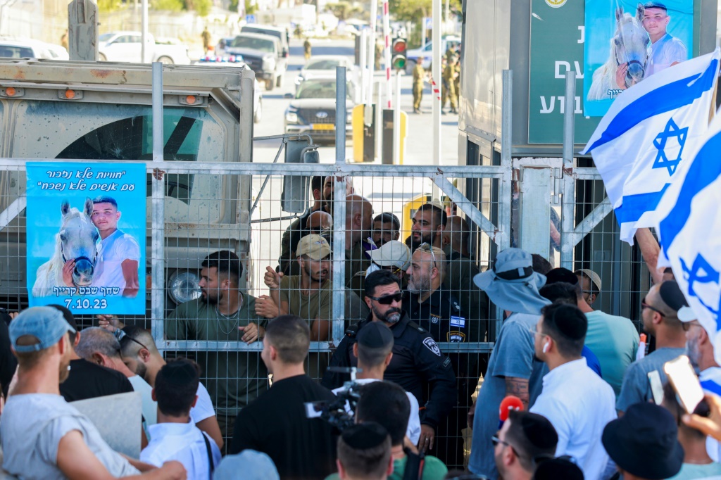 مناصرون لليمين المتطرف الإسرائيلي يتظاهرون أمام مركز احتجاز سدي تيمان في جنوب الدولة العبرية، احتجاجا على التحقيق مع جنود بشبهة إساءة معاملة معتقل فلسطيني، في 29 تموز/يوليو 2024 (ا ف ب)