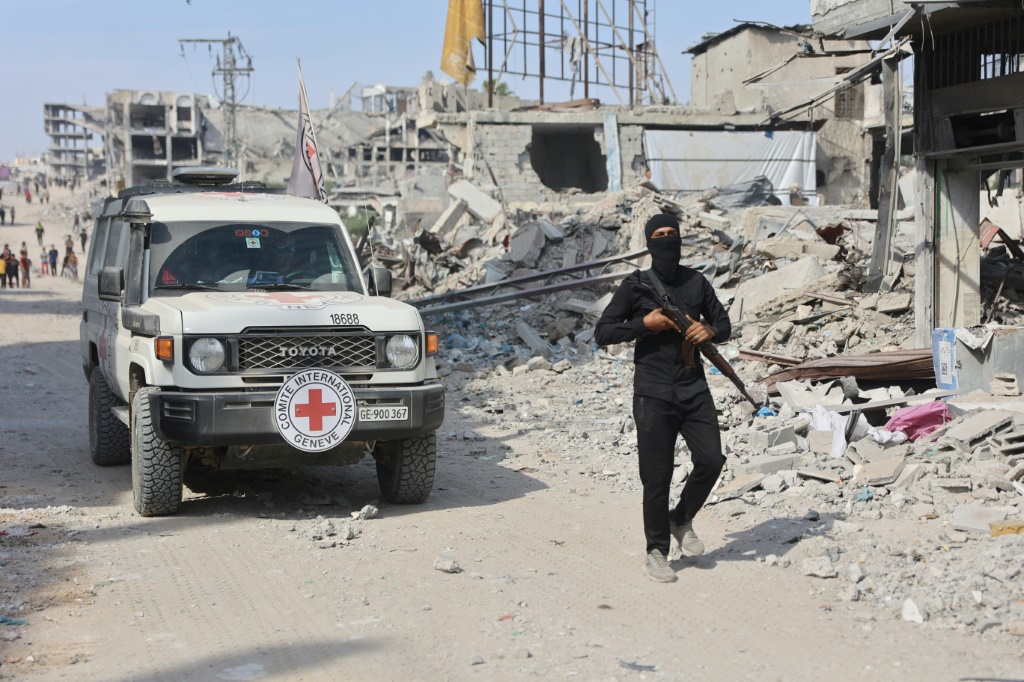 عنصر من حركة حماس أمام سيارة للصليب الأحمر الدولي أثناء البحث عن جثث رهائن إسرائيليين في قطاع غزة في الثاني من تشرين الثاني/نوفمبر 2025 (ا ف ب)