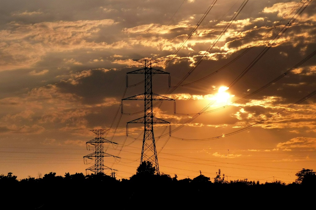 أبراج نقل الكهرباء ذات الجهد العالي عند غروب الشمس في غرب طهران في 2 آب/أغسطس 2025 (ا ف ب)