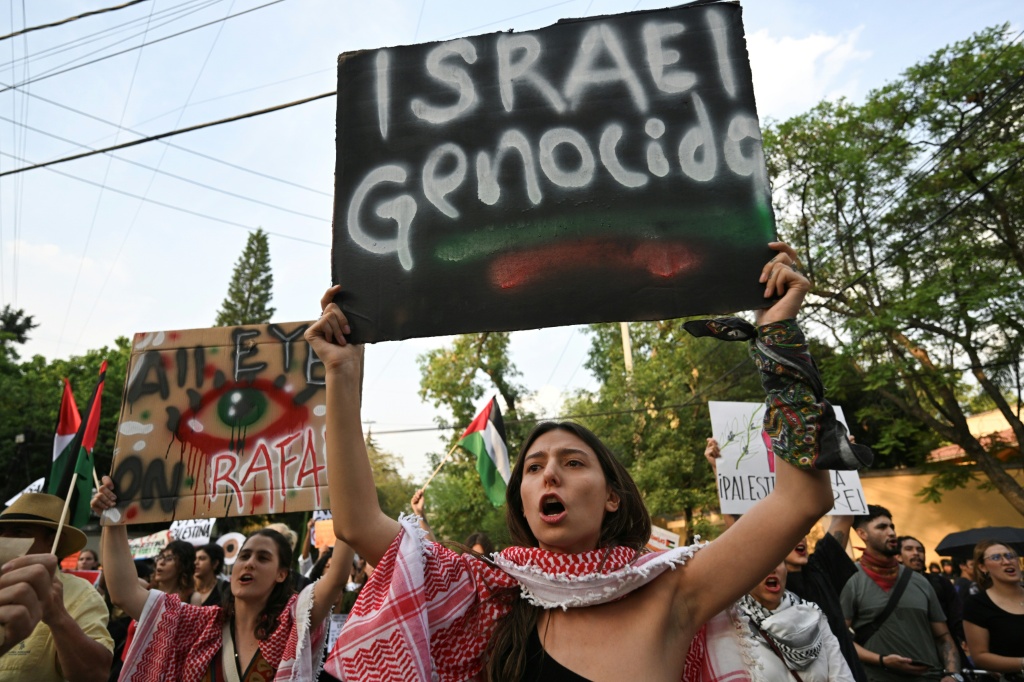 متظاهرة ترفع لافتة منددة بإسرائيل أثناء تظاهرة داعمة لغزة أمام السفارة الإسرائيلية في مكسيكو بتاريخ 28 أيار/مايو 2024 (ا ف ب)