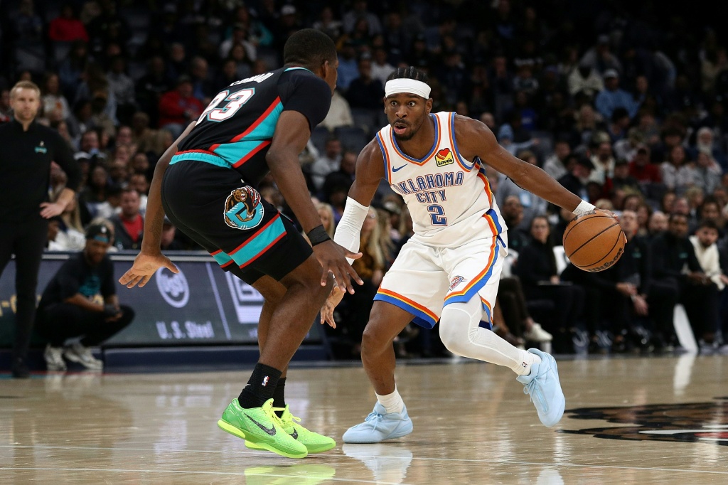 الكندي شاي غلجيوس-ألكسندر لاعب اوكلاهوما سيتي ثاندر يحاول الاختراق وسط مضايقة دفاعية من سيدريك كاورد لاعب ممفيس غريزليز خلال لقاء الفريقين ضمن دوري كرة السلة الأميركي الأحد في 9 تشرين الثاني/نوفمبر 2025 (ا ف ب)