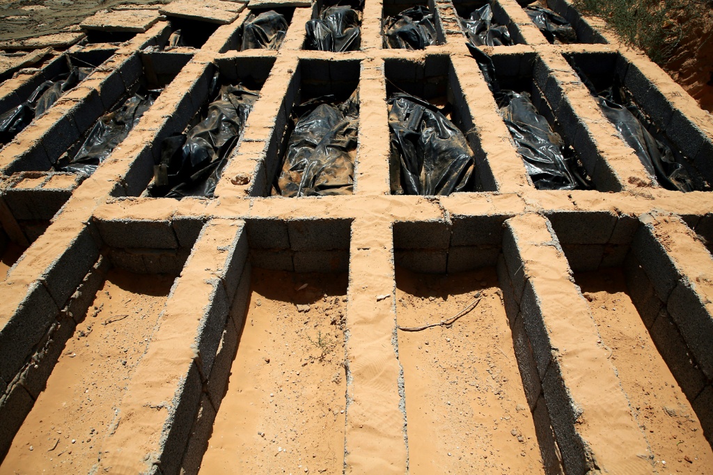 صورة التقطت بتاريخ 28 تموز/يوليو 2019 لجثث مهاجرين لقوا حتفهم في غرق مركب قبالة السواحل الليبية مدفونة في مقبرة في تاجوراء (ا ف ب)