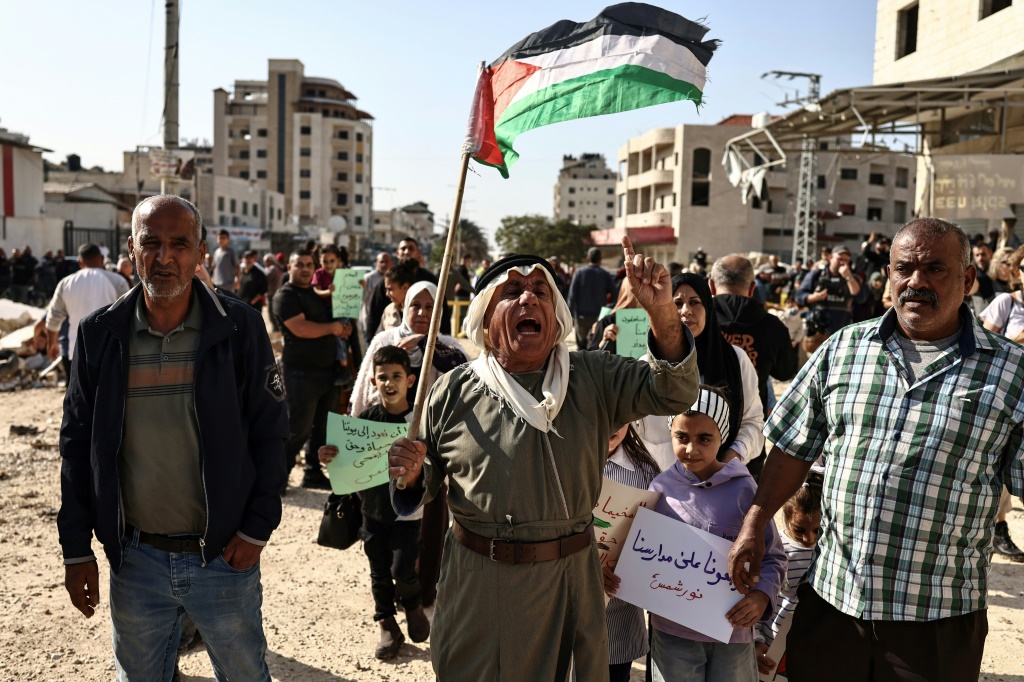 سكان مخيم نور شمس للاجئين الفلسطينيين قرب طولكرم في شما لالضفة الغربية المحتلة يتظاهرون في 18 تشرين الثاني/نوفمبر 22025 مطالبين بالعودة إلى منازلهم بع عشرة أشهر على النزوح منها جراء عملية الجيش الإسرائيلي "السور الحديدي". (ا ف ب)