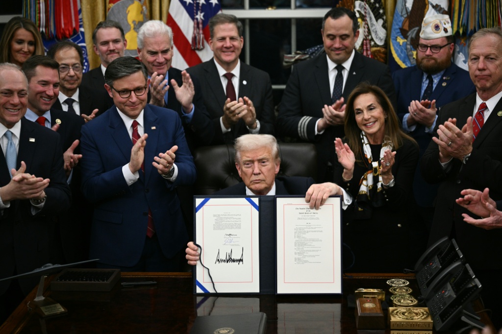 الرئيس الأميركي دونالد ترامب يعرض مراسيم تنفيذية وقعها في البيت الأبيض في 12 تشرين الثاني/نوفمبر 2025 (ا ف ب)